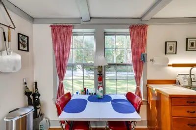 a kitchen with a table with red chairs and a window at Tranquil 3 BR Stockbridge House with Private Deck! in Stockbridge