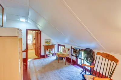 an attic room with a staircase with a table and chairs at Tranquil 3 BR Stockbridge House with Private Deck! in Stockbridge