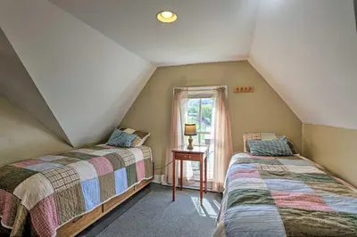 a attic bedroom with two beds and a window at Catskills House 1 Mi to Windham Mountain Resort! in Windham
