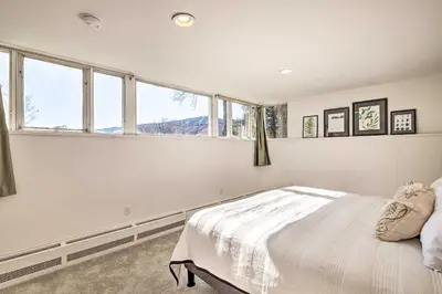 a bedroom with white walls and windows and a bed at Pristine West Dover Home with Deck and Mountain Views! in West Dover