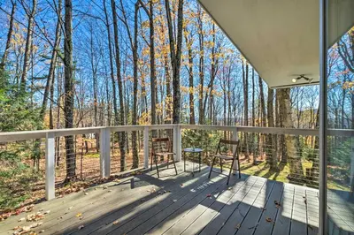 a porch with two chairs and a table in the woods at Pristine West Dover Home with Deck and Mountain Views! in West Dover