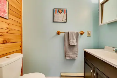 a bathroom with a toilet and a sink at High Peak Heaven Cozy Log Cabin on 1 Acre! in Windham