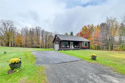a small cabin in the middle of a field at High Peak Heaven Cozy Log Cabin on 1 Acre! in Windham