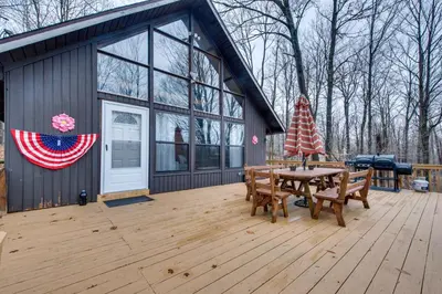 a house with a picnic table and an american flag at Fire Pit and Community Perks Gouldsboro Cabin! in Gouldsboro