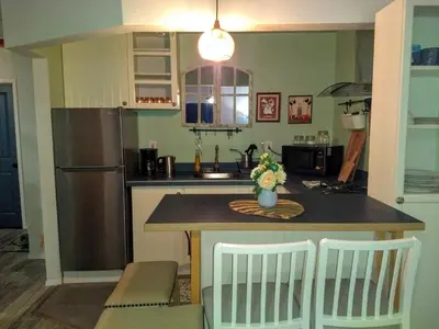 a kitchen with a counter with a refrigerator and a table at Explore New York from Queens in Queens