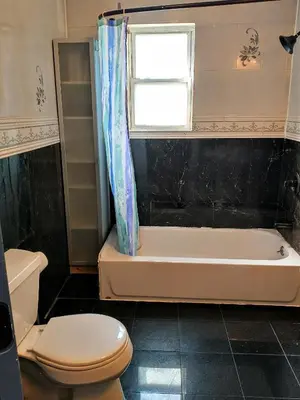 a bathroom with a tub and a toilet and a window at Explore New York from Queens in Queens