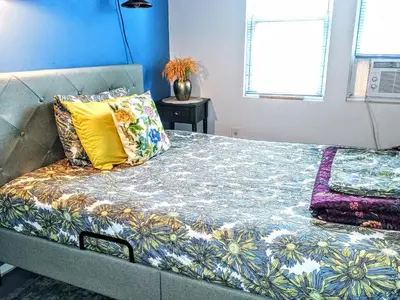a bed with colorful pillows on it in a room at Explore New York from Queens in Queens