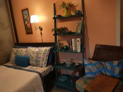 a bedroom with a bed and a chair and a table at Cozy studio at the heart of Jackson Heights in Queens