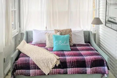 a bed with a blanket and pillows on it at Cozy Stockbridge Cabin - Walk to Beach and Lake! in Stockbridge