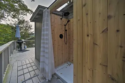 a shower on the side of a wooden building at Cozy Stockbridge Cabin - Walk to Beach and Lake! in Stockbridge