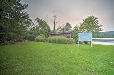 a sign in the grass in front of a house at Cozy Stockbridge Cabin - Walk to Beach and Lake! in Stockbridge