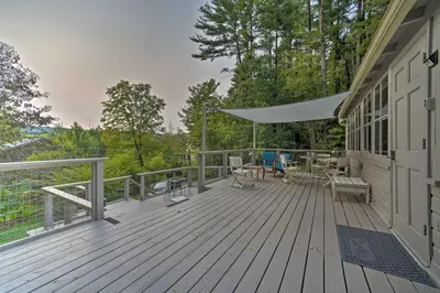 a wooden deck with a table and chairs on it at Cozy Stockbridge Cabin - Walk to Beach and Lake! in Stockbridge
