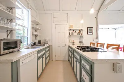 a kitchen with a sink and a stove top oven at Cozy Stockbridge Cabin - Walk to Beach and Lake! in Stockbridge