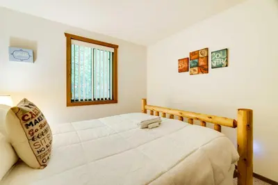 a bedroom with a bed and a window at Fire Pit and Games! Secluded Chalet 30 Mi to Montage in Lake Ariel