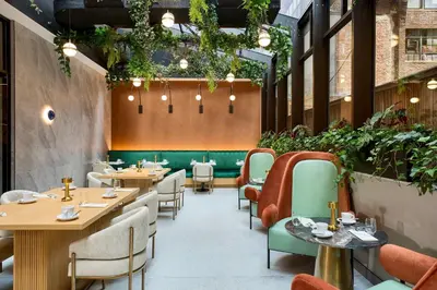 a restaurant with tables and chairs and plants at Delta Hotels by Marriott New York Times Square in New York
