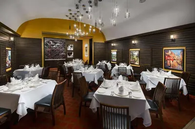 a dining room with white tables and chairs at Hilton Garden Inn New York Times Square North in New York
