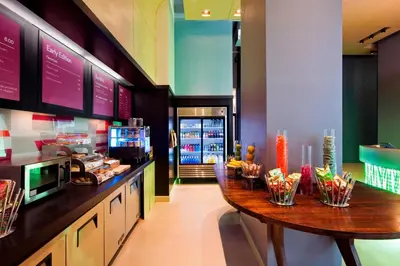 a kitchen with a wooden table in a restaurant at Aloft Manhattan Downtown - Financial District in New York
