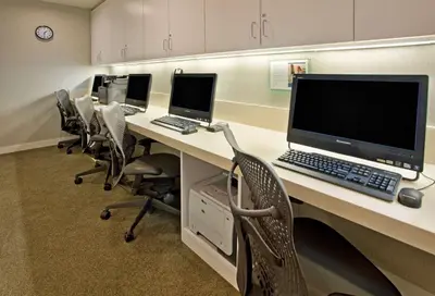 an office with a row of desks with computers on them at Hilton Garden Inn New York Central Park South-Midtown West in New York