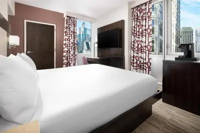 a bedroom with a large white bed and a large window at Hilton Garden Inn New York - Times Square Central in New York