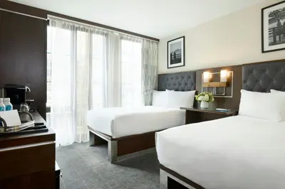 a hotel room with two beds and a window at Archer Hotel New York in New York