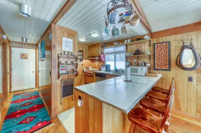 a kitchen with wood paneling and a counter and chairs at Mount Snow Chalet in West Dover