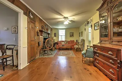 a living room with a large wooden cabinet and a couch at Historic Huntington Home - Walk to Westfield River in Huntington