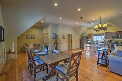 a dining room and living room with a wooden table at Luxe Green Barn Near Skiing with Mt Equinox Views! in Manchester Center