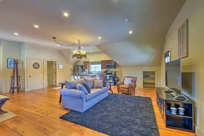 a living room with a blue couch and a rug at Luxe Green Barn Near Skiing with Mt Equinox Views! in Manchester Center