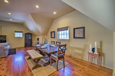 a dining room with a wooden table and chairs at Luxe Green Barn Near Skiing with Mt Equinox Views! in Manchester Center