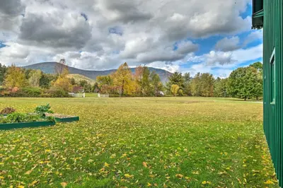 a large field with trees and mountains in the background at Luxe Green Barn Near Skiing with Mt Equinox Views! in Manchester Center