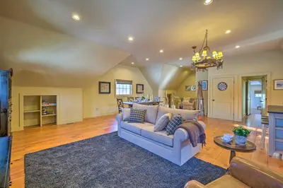 a living room with a couch and a table at Luxe Green Barn Near Skiing with Mt Equinox Views! in Manchester Center