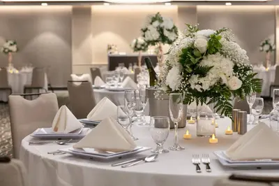 a table with a white table cloth and a vase of flowers at Hyatt Place Fort Lee/George Washington Bridge in Fort Lee
