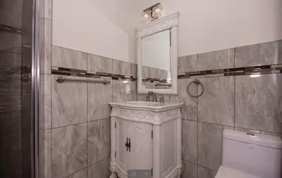 a bathroom with a sink and a toilet and a mirror at Cold Spring Hotel in Cold Spring