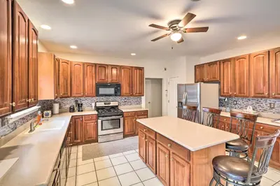 a kitchen with wooden cabinets and a ceiling fan at Blue Mtn Lake Family House, Steps to Beach! in East Stroudsburg