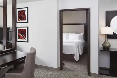 a bedroom with a bed and a desk and a mirror at Cambria Hotel White Plains - Downtown in White Plains