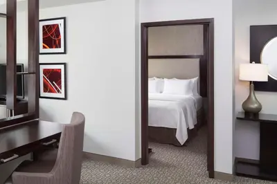 a bedroom with a bed and a desk and a mirror at Cambria Hotel White Plains - Downtown in White Plains