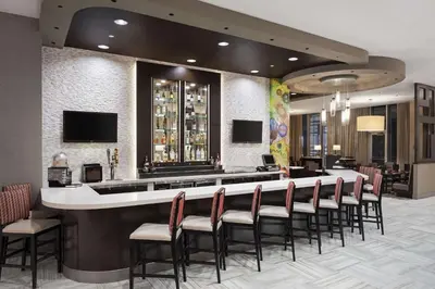 a bar in a restaurant with a bunch of chairs at Cambria Hotel White Plains - Downtown in White Plains