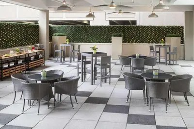 a restaurant with tables and chairs and a bar at Cambria Hotel White Plains - Downtown in White Plains