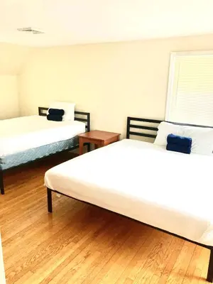 two beds in a room with wooden floors at Town Plot Waterbury in Waterbury