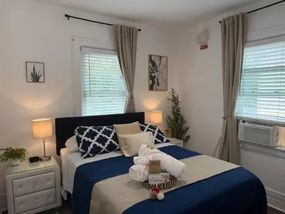 a bedroom with a bed with a blue comforter at Cozy Private bedrooms Kitchen Wifi in Englewood