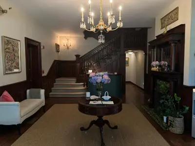 a living room with a chandelier and a table with flowers on it at The West Lane Inn in Ridgefield