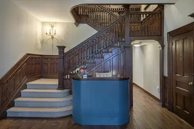 a room with a staircase with a blue table and a stair case at The West Lane Inn in Ridgefield