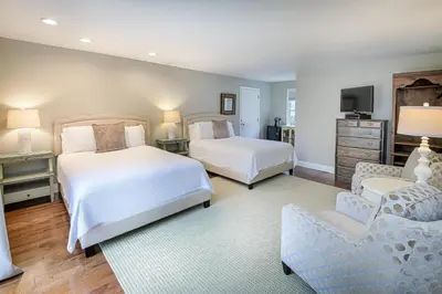 a bedroom with two beds and a couch and a tv at The West Lane Inn in Ridgefield