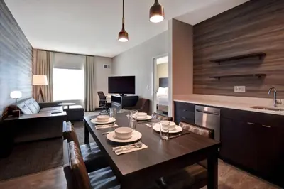 a kitchen and dining room with a dining table and a room with at Residence Inn Middletown Goshen in Middletown
