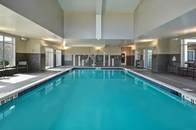 a large swimming pool with blue water in a building at Residence Inn Middletown Goshen in Middletown