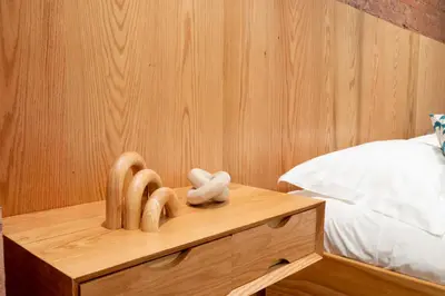 a wooden table with two towels on top of a bed at Morris Guest House in Bronx