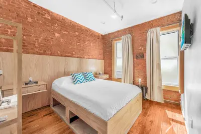 a bedroom with a bed and a brick wall at Morris Guest House in Bronx