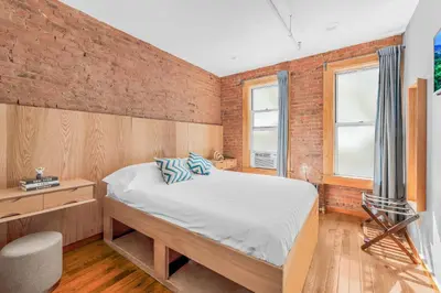 a bedroom with a bed and a brick wall at Morris Guest House in Bronx