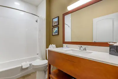 a bathroom with a sink and a toilet and a mirror at Comfort Inn Brewster in Brewster