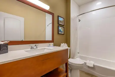 a bathroom with a sink and a toilet and a mirror at Comfort Inn Brewster in Brewster
